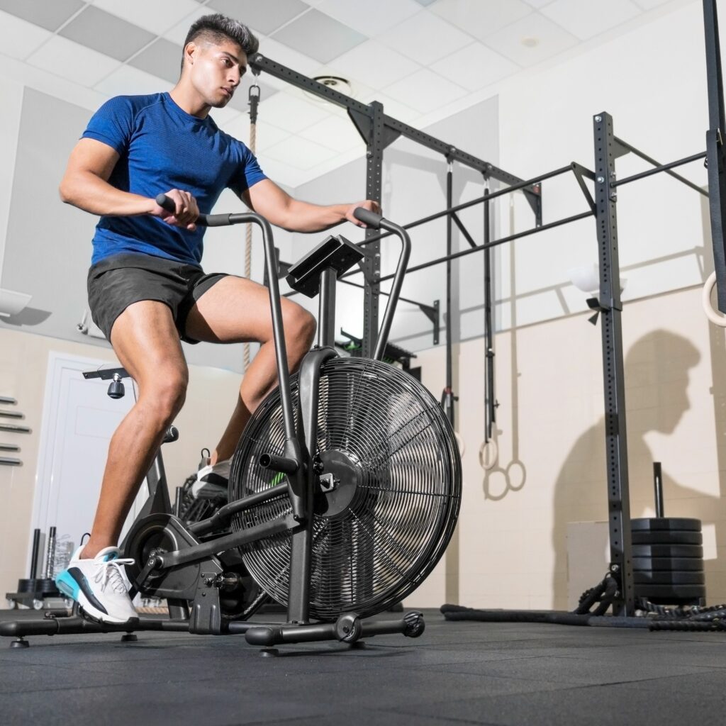 Boy in gym working out on an air bike
