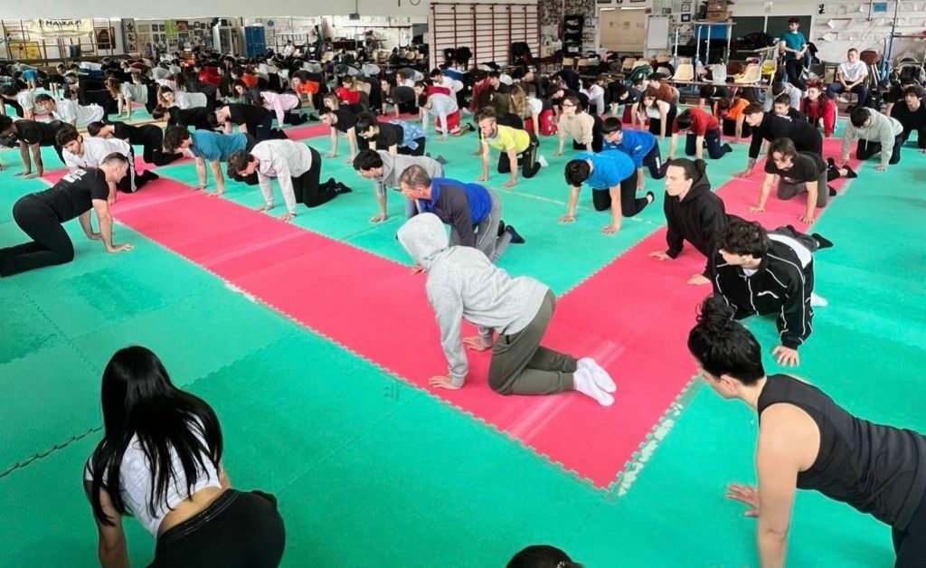 Gymnasium room where an event is taking place: the participating children are performing an exercise